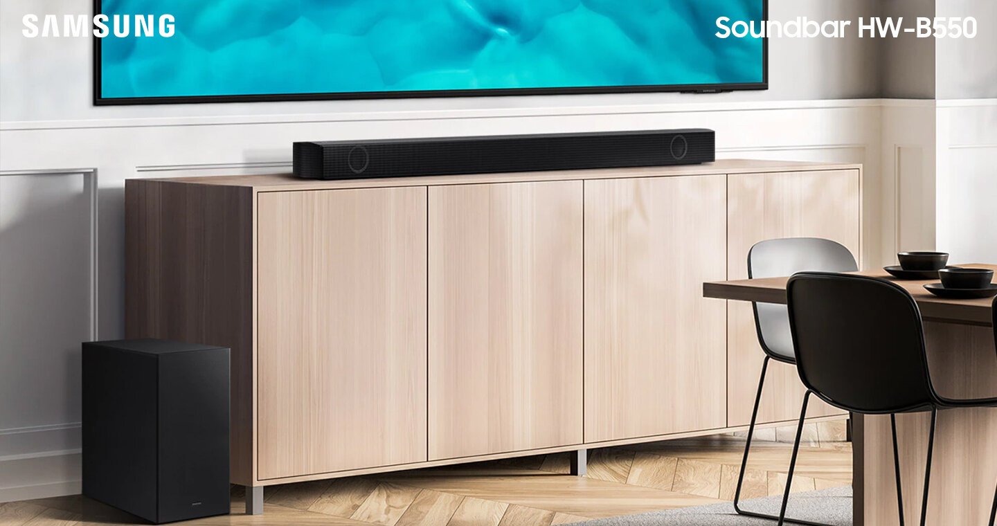 Soundbar Samsung serii B i subwoofer stojące razem z telewizorem Crystal UHD na szafce. HW-B550/EN